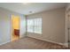 Bright bedroom with neutral walls and carpet features a sun-filled window, and access to the bathroom at 7108 Kinley Commons Ln, Charlotte, NC 28278