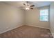 Neutral bedroom with carpeted floors, ceiling fan, and bright window at 7108 Kinley Commons Ln, Charlotte, NC 28278