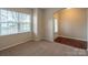 Bedroom featuring plush carpeting and a large window overlooking the front yard at 7108 Kinley Commons Ln, Charlotte, NC 28278