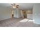 The bonus room features a ceiling fan, plush carpet, and leads to the bathroom and stairs at 7108 Kinley Commons Ln, Charlotte, NC 28278
