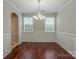Dining room featuring chair-rail molding, hardwood floors, and a contemporary chandelier at 7108 Kinley Commons Ln, Charlotte, NC 28278