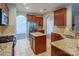 Well-lit kitchen featuring stainless steel appliances, cherry cabinets, and granite countertops at 7108 Kinley Commons Ln, Charlotte, NC 28278