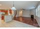 Open-concept living area with hardwood floors, fireplace, and seamless transition to the kitchen at 7108 Kinley Commons Ln, Charlotte, NC 28278