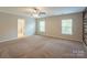Expansive main bedroom featuring a ceiling fan, a wooden accent wall, and neutral carpeting at 7108 Kinley Commons Ln, Charlotte, NC 28278