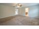 Spacious carpeted main bedroom with a ceiling fan, neutral walls, and natural lighting at 7108 Kinley Commons Ln, Charlotte, NC 28278