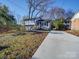 Newly renovated ranch home with a blue door and driveway at 8208 Doverdale Ln, Charlotte, NC 28217