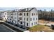 Angled daytime exterior shot of modern new construction townhomes with white siding at 13024 Moon Rd # 44, Charlotte, NC 28277