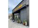 Exterior of Postino restaurant, showcasing a modern design with dark wood accents and potted plants at the entrance at 13024 Moon Rd # 44, Charlotte, NC 28277