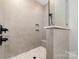 Close-up of a tiled walk-in shower featuring a mosaic floor, a built-in niche, and a shower bench at 267 Triple Ponds Ct # 11, Clover, SC 29710