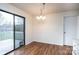 Bright dining area features hardwood floors, elegant chandelier and sliding glass door access to an outdoor deck at 123 23Rd Nw St # E, Hickory, NC 28601