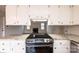 Kitchen showcases stainless steel stove, granite counters, white cabinets, and an open view to the living room at 123 23Rd Nw St # E, Hickory, NC 28601