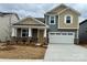 Charming two-story home showcasing a well-manicured lawn and a two-car garage, creating an inviting curb appeal at 2615 Tillman St, Monroe, NC 28112