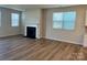 Open living room featuring a fireplace, laminate floors, and ample natural light from large windows at 2615 Tillman St, Monroe, NC 28112