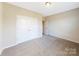 Bright bedroom with neutral walls, plush carpet, and closet with white bi-fold doors at 127 Jentri Way, Mooresville, NC 28115