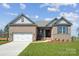 Charming brick home features a manicured lawn, attached garage, and stylish architectural details at 127 Jentri Way, Mooresville, NC 28115