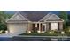 Beautiful brick home features a manicured lawn, attached garage, and stylish architectural details at dusk at 127 Jentri Way, Mooresville, NC 28115