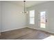 Bright dining room with modern light fixture, wood-look floors, and lots of sunlight at 153 Halite Ln, Waxhaw, NC 28173