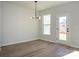 Bright dining room with wood-look flooring, modern light fixture, and access to the outdoors at 153 Halite Ln, Waxhaw, NC 28173