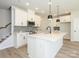 Bright and modern kitchen with white cabinets, a large island, and stainless steel appliances at 153 Halite Ln, Waxhaw, NC 28173
