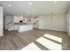 Open concept view of living room into kitchen; the floor is hardwood and lots of natural light at 153 Halite Ln, Waxhaw, NC 28173