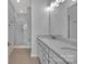 Bright bathroom featuring a double vanity, large mirror, and glass-enclosed shower with white tiling at 582 West End Dr, Charlotte, NC 28208