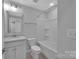 Standard white bathroom featuring a tub-shower combination, white sink cabinet, and tile flooring at 582 West End Dr, Charlotte, NC 28208