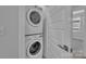 Efficient laundry setup with stacked washer and dryer, located near a window and a door at 582 West End Dr, Charlotte, NC 28208