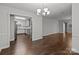 Dining room with hardwood floors, chandelier, and kitchen view at 6641 Melody Ln, Charlotte, NC 28215