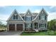 Charming two-story home boasting stone accents, grey siding, black shutters, and an attached two-car garage at Lot 42 Watercourse Way # Hawthorne, Belmont, NC 28012