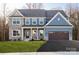 Attractive two-story home featuring stone accents, blue siding, and an attached two-car garage at Lot 42 Watercourse Way # Hawthorne, Belmont, NC 28012