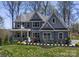 Two-story house with gray siding, stone accents, and wrap-around porch at Lot 51 Watercourse Way # Nottingham, Belmont, NC 28012