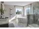 Bright bathroom featuring a standalone tub, tiled floor and walls, and a glass shower at Lot 51 Watercourse Way # Covington, Belmont, NC 28012