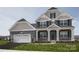 Inviting exterior of a two-story home featuring a stone-accented porch and a two-car garage, adding curb appeal at Lot 51 Watercourse Way # Nottingham, Belmont, NC 28012