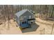 Aerial view of a backyard with a wooden deck featuring black railings and surrounded by trees at 149 Pinewood St, Troutman, NC 28166