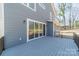 Back of house with sliding glass doors leading to large deck overlooking a wooded backyard at 149 Pinewood St, Troutman, NC 28166