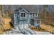Two-story home with a two-car garage, gray siding, and white trim, surrounded by a wooded area at 149 Pinewood St, Troutman, NC 28166