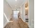 Hallway leading to an open living space, a bathroom, and stairs with hardwood floors at 149 Pinewood St, Troutman, NC 28166