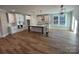 Spacious kitchen with white cabinetry, an island with a sink, and stainless steel appliances on hardwood flooring at 149 Pinewood St, Troutman, NC 28166