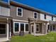 Backyard view of modern two-story home, showcasing well-maintained lawn and covered patio area at 157 Halite Ln, Waxhaw, NC 28173