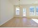 Dining room with modern chandelier, wood floor, and a view through multiple windows and glass door at 157 Halite Ln, Waxhaw, NC 28173