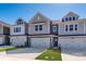 Charming townhomes featuring a two-car garage, neutral siding, and manicured lawns on a sunny day at 157 Halite Ln, Waxhaw, NC 28173
