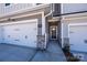 Inviting townhome entrance with stone accents and a pathway to the front door and two-car garage at 157 Halite Ln, Waxhaw, NC 28173