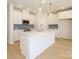 Modern kitchen features white cabinetry, a large island, stainless steel appliances, and pendant lighting at 157 Halite Ln, Waxhaw, NC 28173