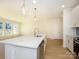 Contemporary kitchen island with a stainless steel sink, light cabinets, and stylish pendant lighting at 157 Halite Ln, Waxhaw, NC 28173