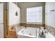 Bright bathroom featuring a soaking tub with mosaic tile surround and a window for natural light at 2221 Hartwell Ln, Fort Mill, SC 29707