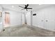 Spacious bedroom with gray carpet, ceiling fan, and multiple closets and entryways at 5034 Clearwater Lake Rd, Mount Holly, NC 28120