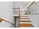 Wooden staircase leading to the main level with wrought iron railing details at 5034 Clearwater Lake Rd, Mount Holly, NC 28120