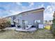 Large backyard features a stone patio with furniture, firepit, and a well maintained lawn at 913 Deep River Way, Waxhaw, NC 28173