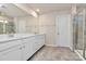 Bright bathroom with dual sinks, quartz countertops, and a framed mirror over white cabinets at 913 Deep River Way, Waxhaw, NC 28173