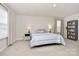 Bright bedroom with carpeted floors, bedside lamps, a comfy bed, and bookshelf storage at 913 Deep River Way, Waxhaw, NC 28173